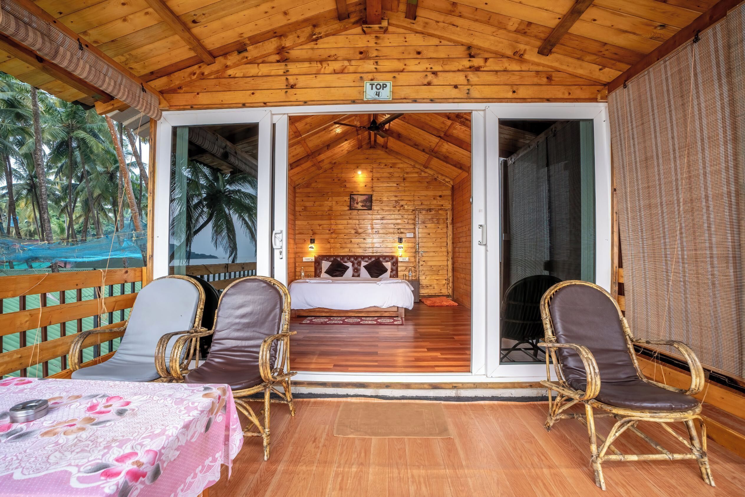 Una cabaña de madera con una cama, dos sillas y una mesa.