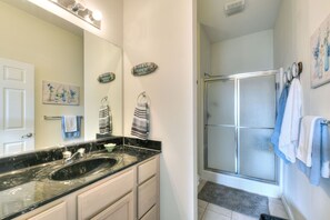 Bathroom features a large mirror, sink, and glass shower enclosure.
