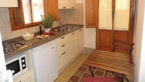 A compact kitchen with white cabinets, a sink, a stove, and a microwave. - Dimora Pieri - Corsini Apartment, historic building  in the old center with lift and terrace (Firenze)