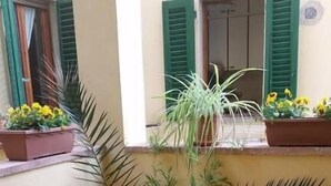 A small outdoor seating area with a table and chairs, potted plants, and a window with shutters. - Dimora Pieri - Corsini Apartment, historic building  in the old center with lift and terrace (Firenze)