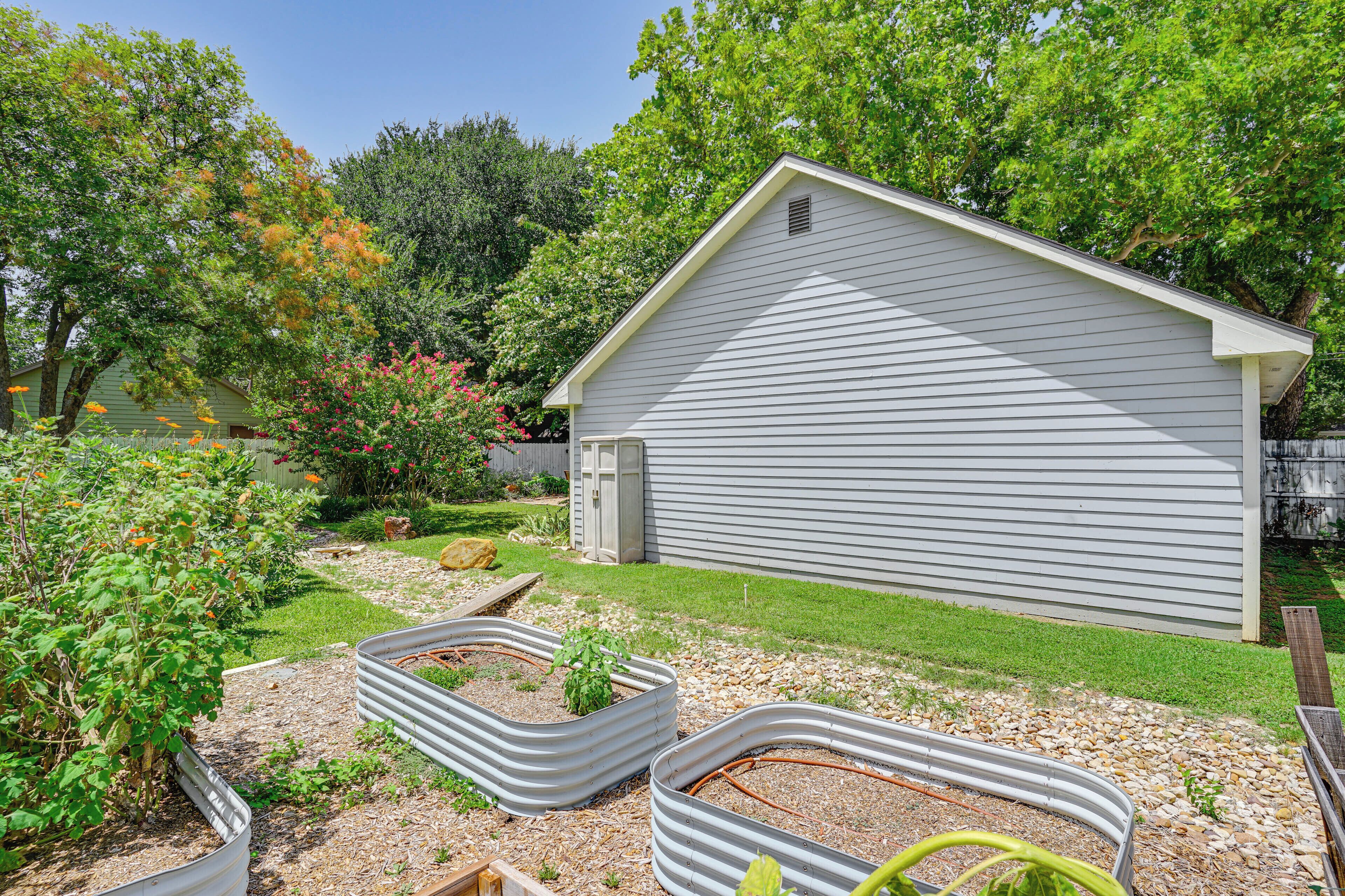 A residential property with a small shed, a garden with raised beds, and a lawn.