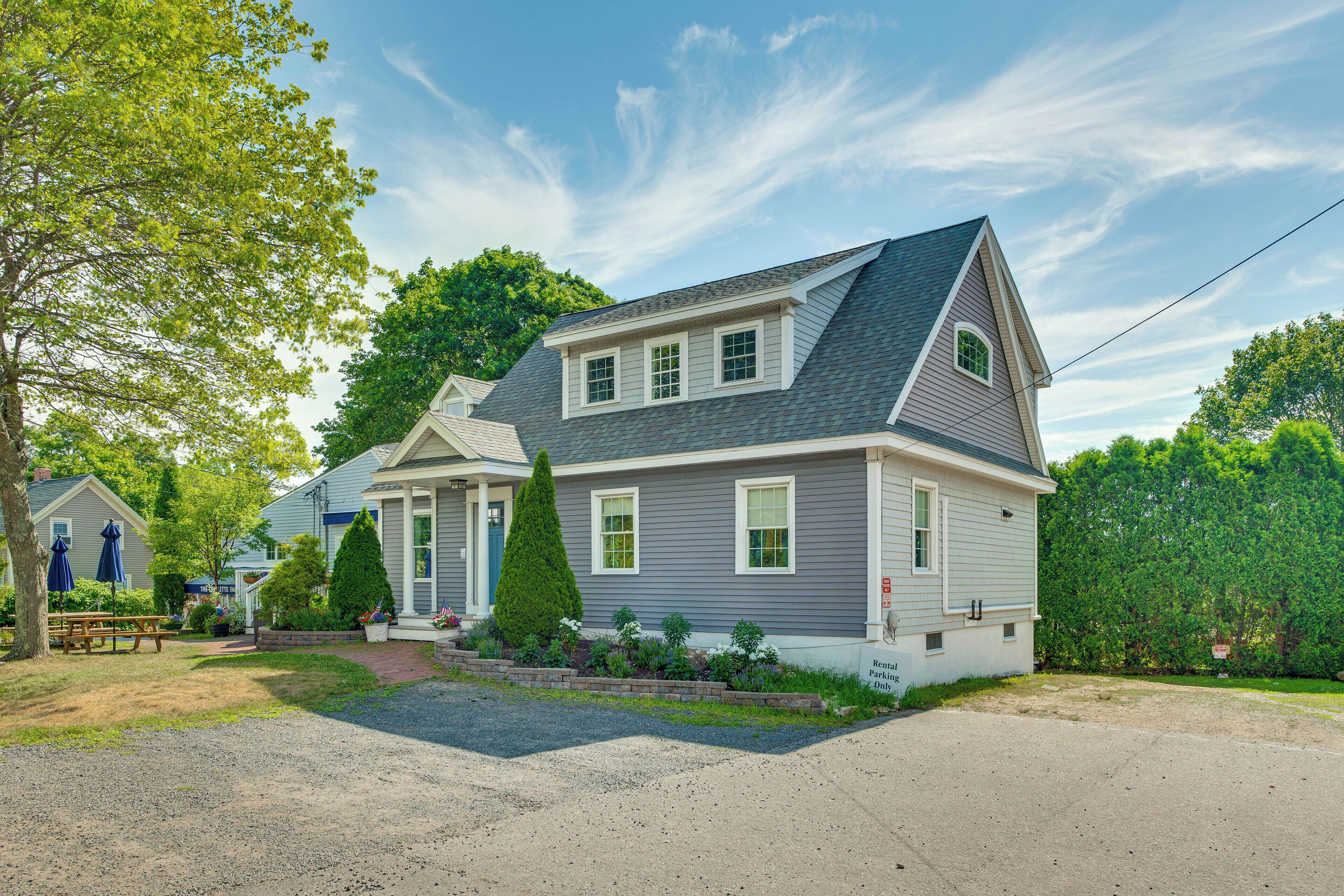 A two-story house with a front porch, a driveway, and a well-maintained lawn.