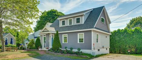 A two-story house with a front porch, a driveway, and a well-maintained lawn.