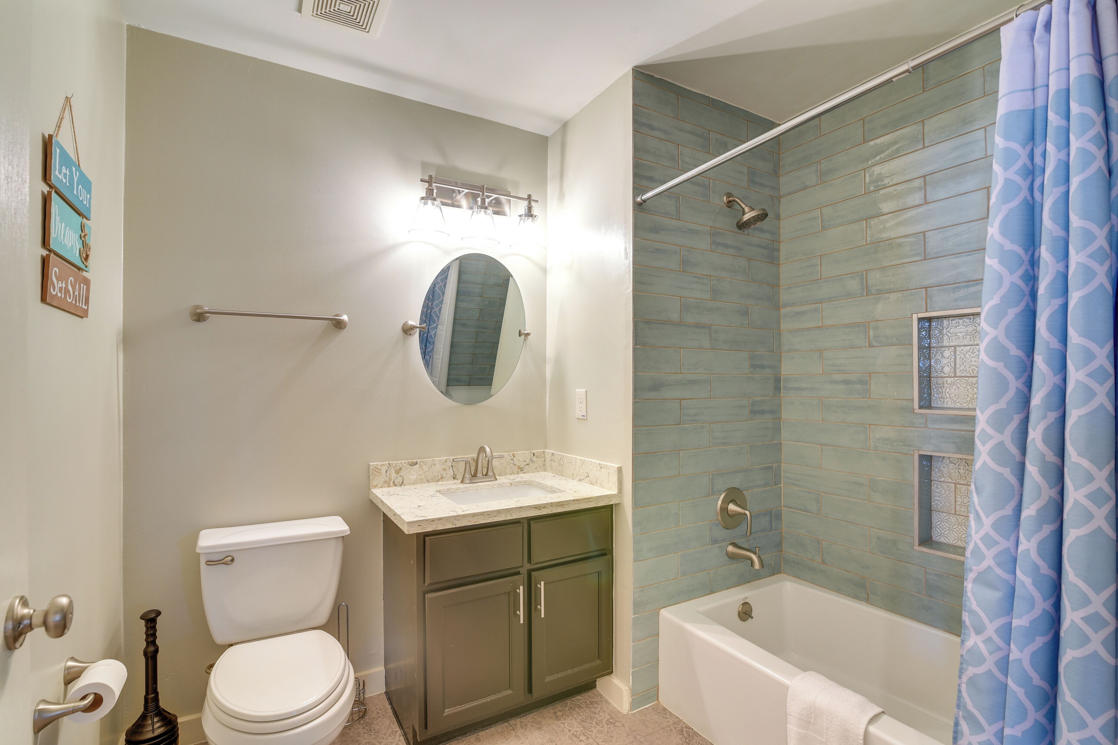 A bathroom with a toilet, sink, and bathtub.