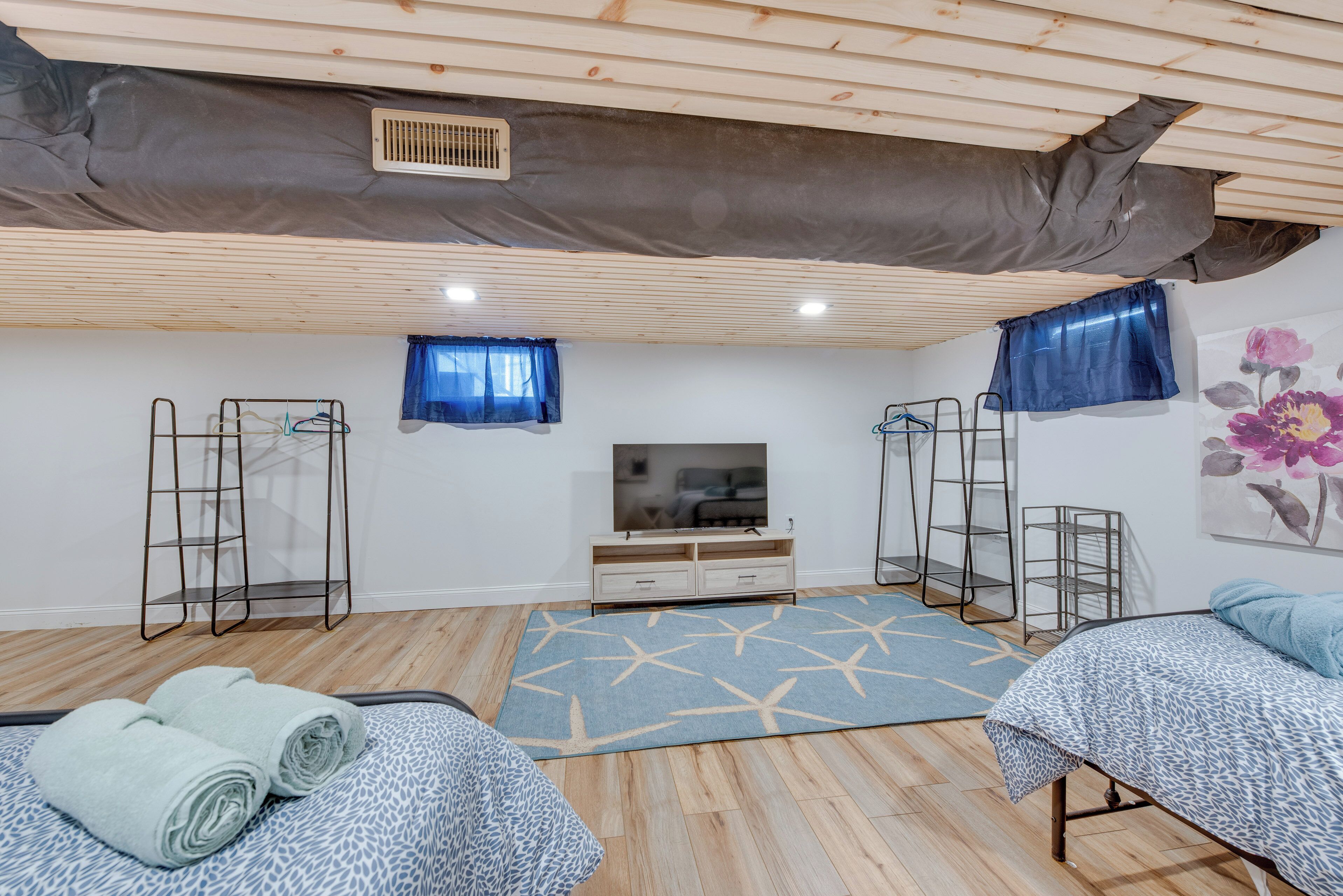 A bedroom with a bunk bed, a TV, a desk, and a window with curtains.