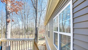 A wooden deck with a view of a forest and a house with large windows. - Lovely Scottsville Home, Minutes to Bowling Green (Scottsville)