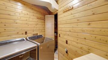 Un cuarto de sauna con paredes de madera y un banco.