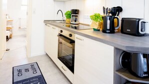 A modern kitchen with white cabinets, a built-in oven, a coffee maker, and a toaster. - Vacation in the countryside - adventure and relaxation - what (Schellhorn)