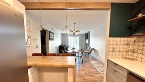 A modern kitchen with wooden flooring, a central island, and pendant lighting. - Wheelhouse: Lakefront 2BD/3BA/Deck/Pool/Pet Friendly-6PP (Lake Ozark)