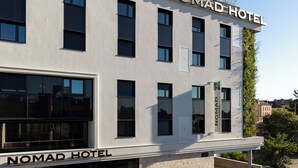 Un edificio moderno con il cartello 'Nomad Hotel' che indica la sua funzione di hotel.