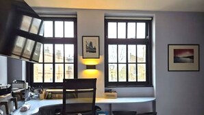 Eine kleine Küche mit Fenster, Stuhl und Spüle.