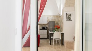 Eine kompakte Küche mit Kühlschrank, Mikrowelle und einer Essecke mit Tisch und Stühlen.
