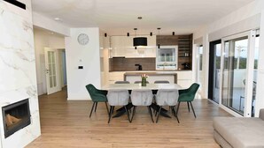 Una cocina moderna con comedor, suelo de madera y chimenea.