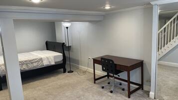 A bedroom with a bed, a desk, and a chair.