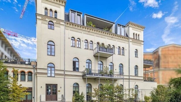 A multi-story building with a symmetrical facade, multiple balconies, and a central entrance. - Cityloft Gold - im Zentrum. Inkl. Parken, Netflix (Leipzig)