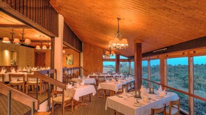 Un restaurant doté de nombreuses tables pour les clients, d’un décor intérieur en bois et de grandes fenêtres offrant une vue sur l’extérieur.