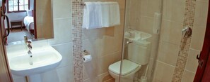 A bathroom with a sink, toilet, and glass shower enclosure.
