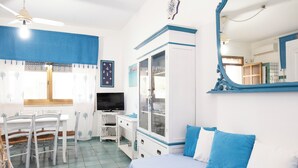 A room with a bed, a desk, a television, and a cabinet.