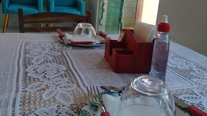 A dining table set with plates, cutlery, and a water bottle. - Pousada Porto dos Reis (Ipojuca)