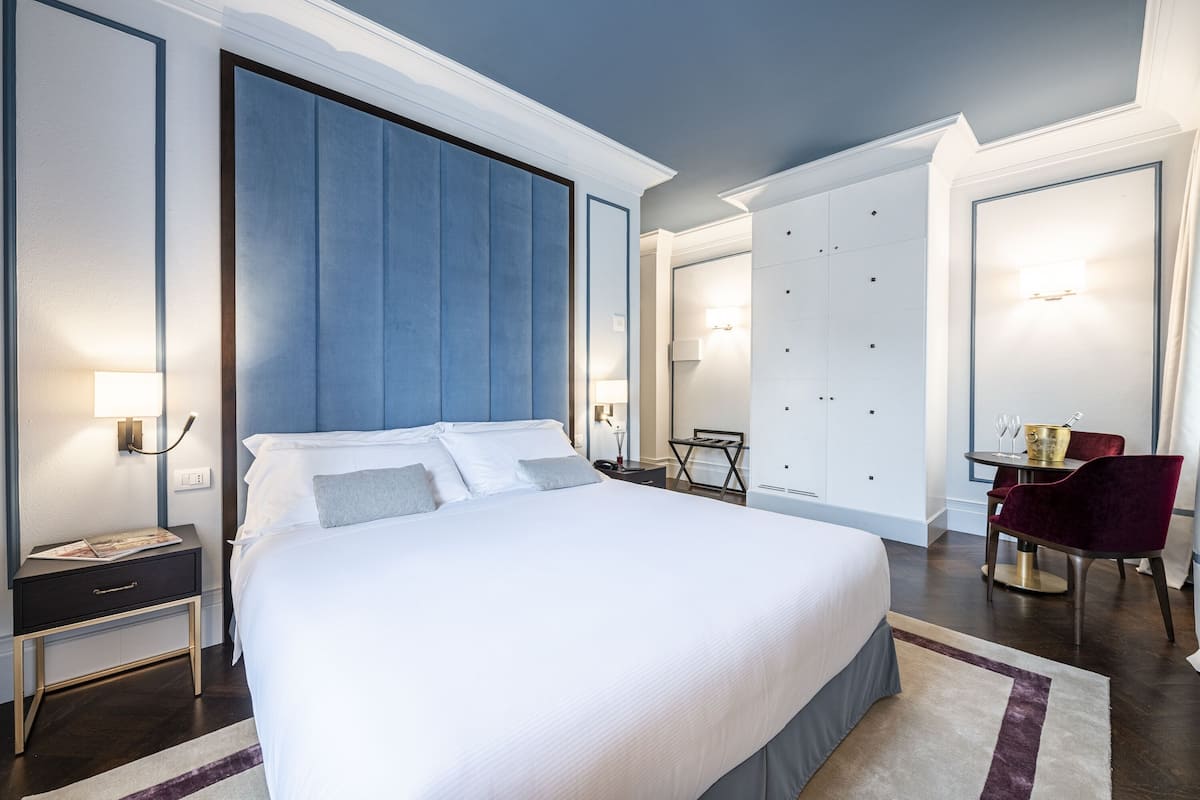 Une chambre d’hôtel moderne dotée d’un grand lit, d’un bureau et d’un coin salon avec une table et des chaises.
