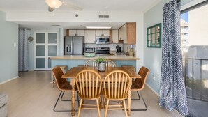 Una cocina moderna con una isla central, sillas de madera y un ventilador de techo.