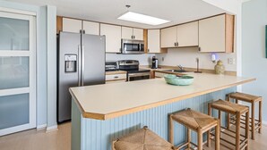 Una cocina moderna con una isla central, electrodomésticos de acero inoxidable y armarios azul claro.