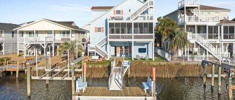 A waterfront property with multiple buildings, a dock, and outdoor seating areas.