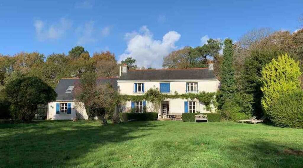 A two-story house with a well-maintained lawn and a small garden area.