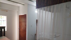 A room with a bed, a wooden door, and a window with blinds. - Hostal Principio Tayrona (Santa Marta)