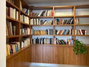 Une bibliothèque avec des étagères en bois remplies de livres.