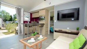 A modern living room with a sofa, a coffee table, and a TV mounted on the wall.