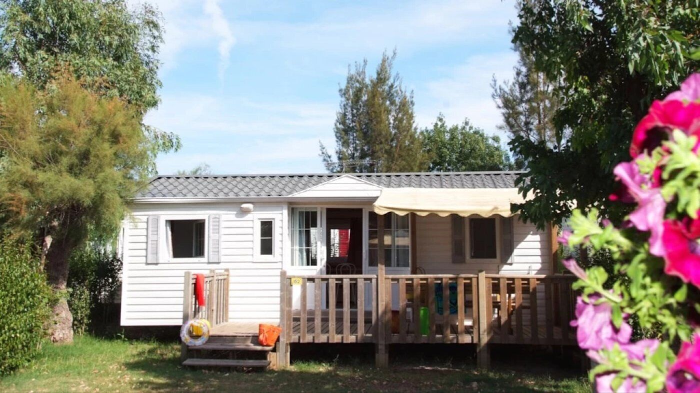 A mobile home with a front porch and a covered deck area.