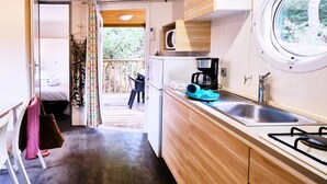 Cocina compacta con ventana, comedor y dormitorio con vistas.