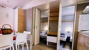 Una habitación compacta con comedor, cama y kitchenette.