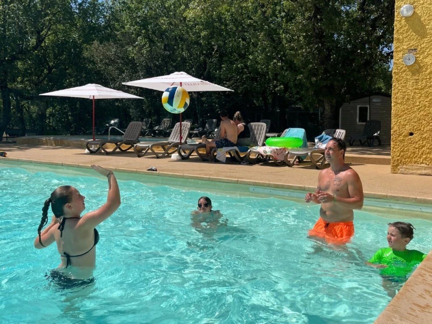 A swimming pool with lounge chairs and umbrellas.
