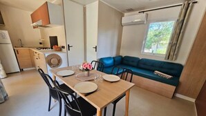 Un espace de vie compact comprenant un coin repas, une kitchenette et un canapé.