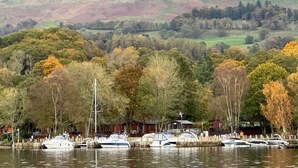 A marina with boats docked, surrounded by trees and hills in the background. - V+B's Hygge, Gorgeous Lake View at V&B Hygge (Troutbeck Bridge)