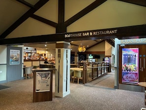 A bar and restaurant area with a sign for 'BOATHOUSE BAR & RESTAURANT' and a claw machine. - V+B's Hygge, Gorgeous Lake View at V&B Hygge (Troutbeck Bridge)