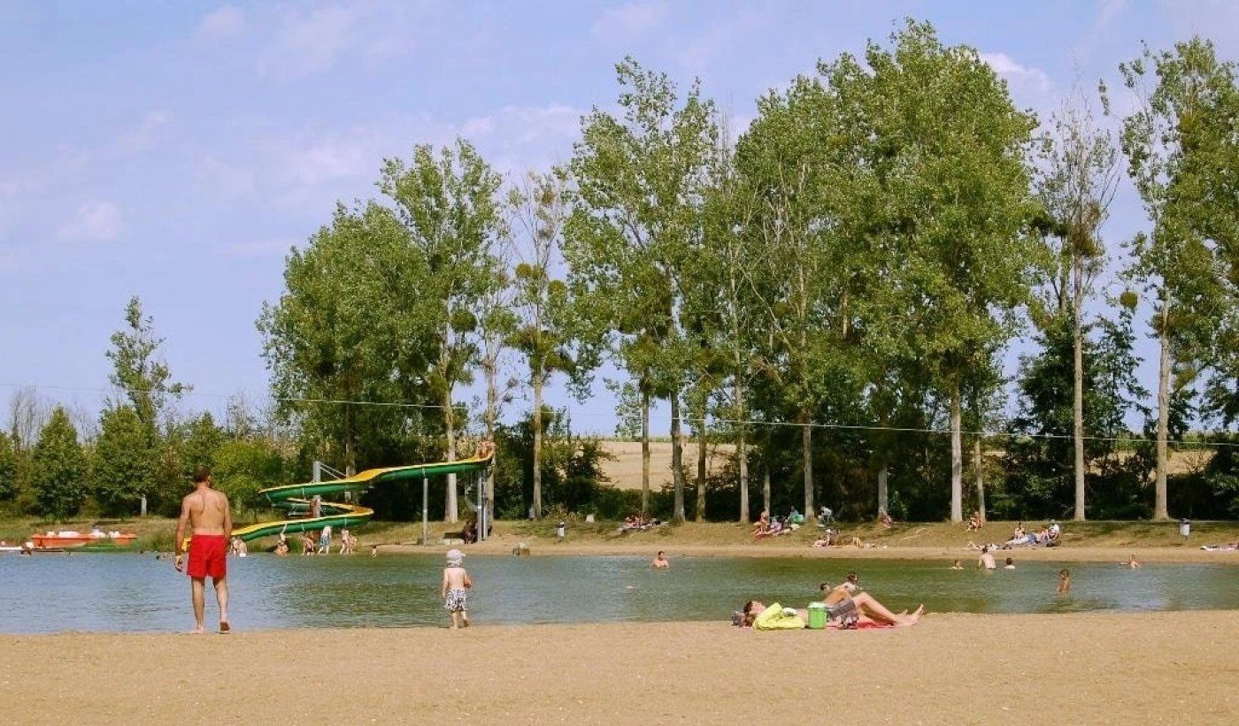 Un parc au bord du lac, doté d’une aire de jeux, d’espaces aménagés pour pique-niquer et où les gens se détendent au bord de l’eau.
