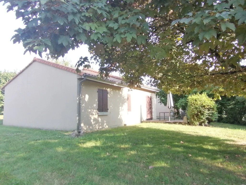 A single-story building with a flat roof, a small porch, and a grassy yard.