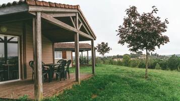 Un bâtiment en bois doté d’un patio couvert et d’un espace extérieur aménagé pour s’asseoir.