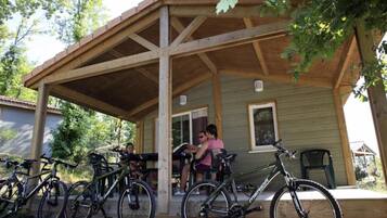 Une véranda en bois, avec des vélos garés devant.