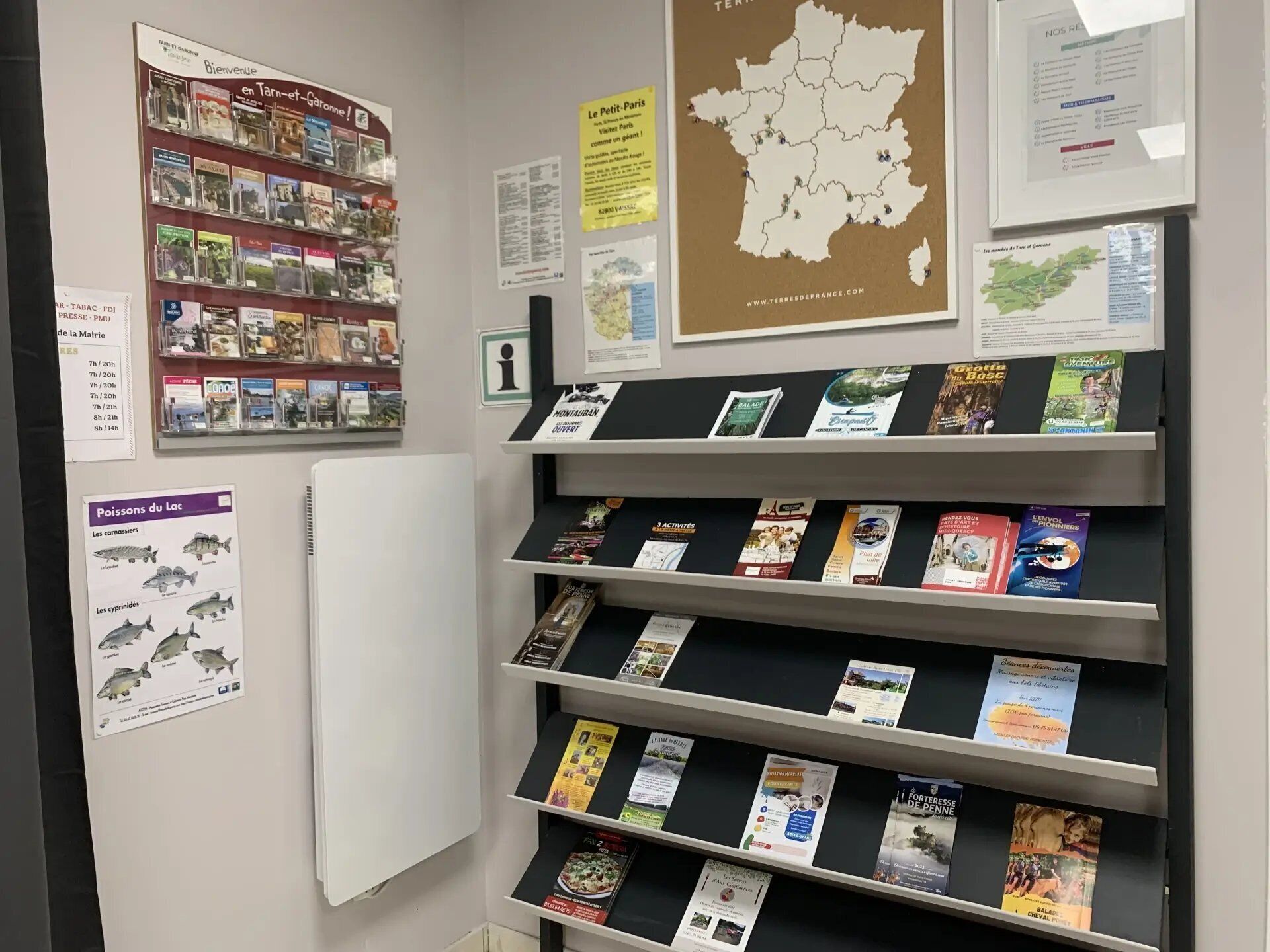 A library or information center with bookshelves, informational posters, and a map of France.