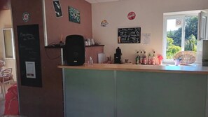 A cafe interior with a counter, menu board, and various items on display.