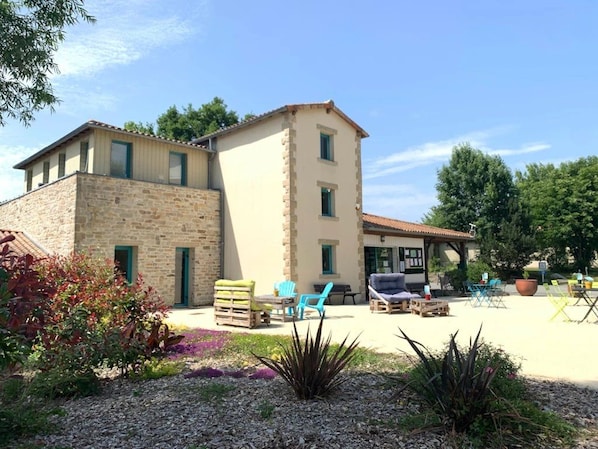 Il s’agit d’un bâtiment à deux étages, doté d’une façade en pierre et d’un toit recouvert de tuiles. On y trouve des espaces extérieurs aménagés avec des chaises et des tables.