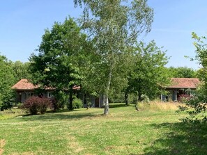 A residential property with a large lawn, two houses with red-tiled roofs, and mature trees. - ZEcamping 3 étoiles piscine animaux acceptés cottage TV LV BBQ 41m2 (Moutiers-sous-Chantemerle)