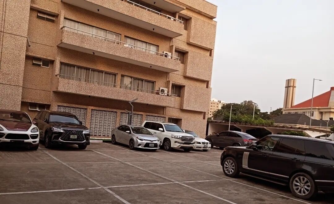 A multi-story building with a parking lot in front.