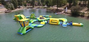 An outdoor water park with inflatable play structures and a sandy area. - ZEcamping 3 étoiles familial piscine dog friendly locatif TV clim 35m2 4 pers (Nailloux)