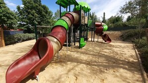 Ein Spielplatz mit Rutsche und Klettergerüsten.