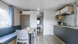 A compact kitchen with a dining area, a built-in bench, and a microwave.